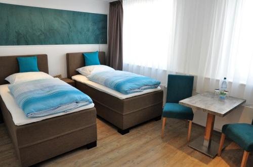 a room with two beds and a table and chairs at Apartments am Freizeitpark in Kriftel