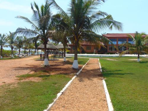 a row of palm trees next to a building at Bojo Beach Resort in Bortianor