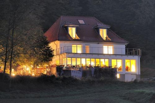 duży biały dom z oświetleniem w nocy w obiekcie Schwedenfrieden w mieście Bielefeld