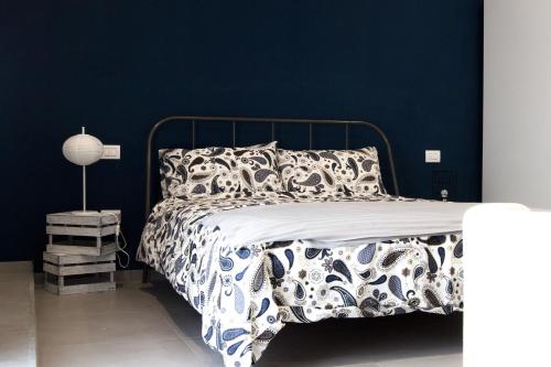 a bedroom with a bed with a blue wall at "Panoramic Terrazza - Napoli" in Naples