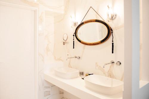 Baño blanco con 2 lavabos y espejo en Une Chambre Chez Dupont, en Burdeos