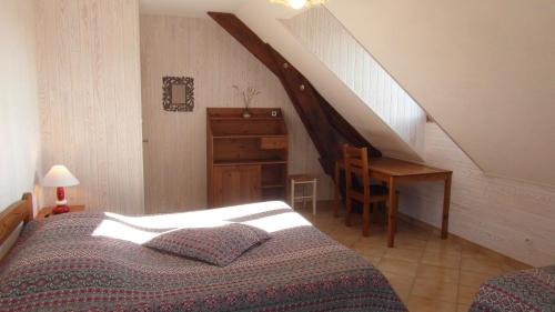 a bedroom with a bed and a desk and a staircase at Au Vieux Tilleul in Veynes