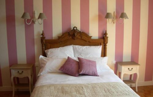 a bed with two pillows and two night stands next to it at Gite de la ferme du couvent in Boran-sur-Oise