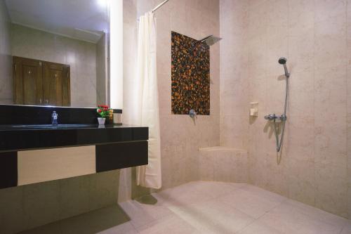 y baño con lavabo y ducha. en Maharani Homestay, en Banyuwangi