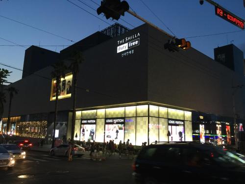 a building on a city street with cars in front of it at Oh Happy Day Jeju in Jeju
