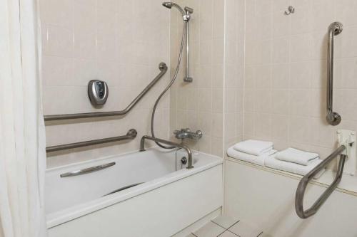 a bathroom with a bath tub and a toilet at Days Inn Stafford in Stafford