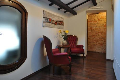 a hallway with two chairs and a table and a mirror at Al Casaletto Hotel in Settecamini