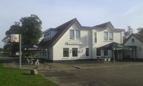 a white house with tables and chairs in front of it at De Twentse Nar in De Lutte