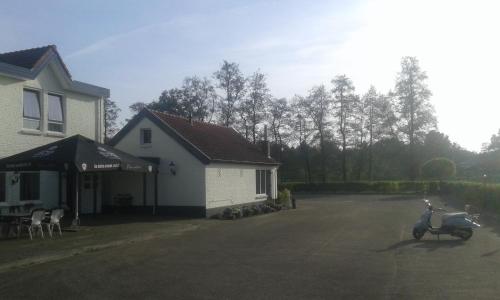 a scooter parked in a parking lot next to a house at De Twentse Nar in De Lutte