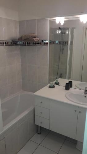 a bathroom with a tub and a sink and a bath tub at DISNEYLAND PARIS/VAL 2 APART' in Montévrain