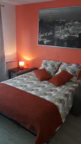 a bedroom with a large bed with red walls at DISNEYLAND PARIS/VAL 2 APART' in Montévrain