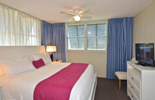 基韋斯特的住宿－Sunrise Suites Antigua Suite #312，一间卧室配有一张床和吊扇
