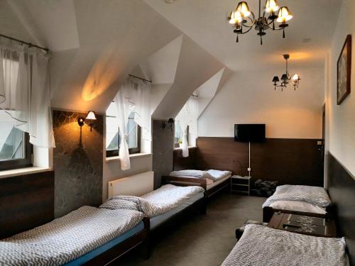 a room with three beds and a chandelier at Pokoje Gościnne z łazienkami przy Wrocławiu, darmowy parking in Długołęka