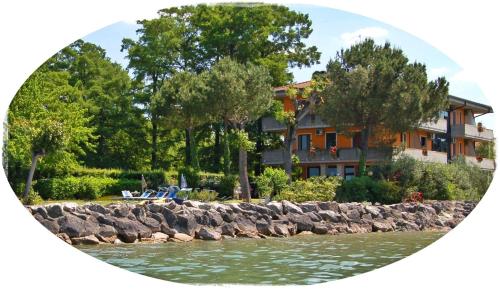 a building next to a body of water with trees at Albergo Il Biancospino in Sirmione