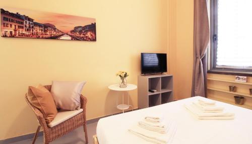 ミラノにあるItalianway-San Pietro all'Ortoのテーブル、椅子、テレビが備わる客室です。