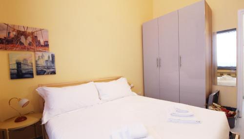 ein Schlafzimmer mit einem weißen Bett und einem Schrank in der Unterkunft Italianway-San Pietro all'Orto in Mailand