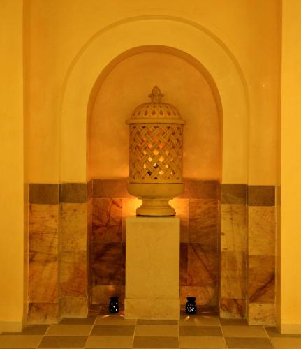 a statue in the corner of a room with an arch at El Mouradi Tozeur in Tozeur
