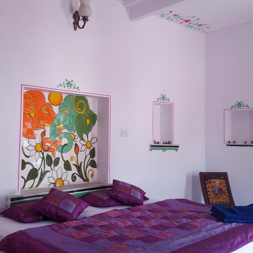 a bedroom with a bed with a painting on the wall at Hari Niwas Guest House in Udaipur