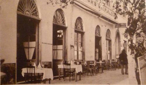 ein altes Foto eines Restaurants mit Tischen und Stühlen in der Unterkunft Hôtel Les Voyageurs in Bastia