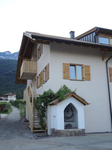 a white building with a staircase and a balcony at Versigglhof in Appiano sulla Strada del Vino
