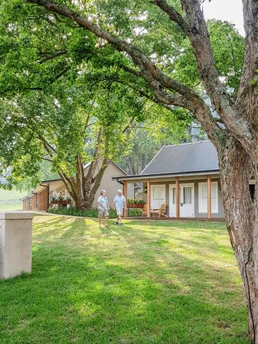 two people walking in the yard of a house at Bosch Hoek Golf & Lodge in Balgowan