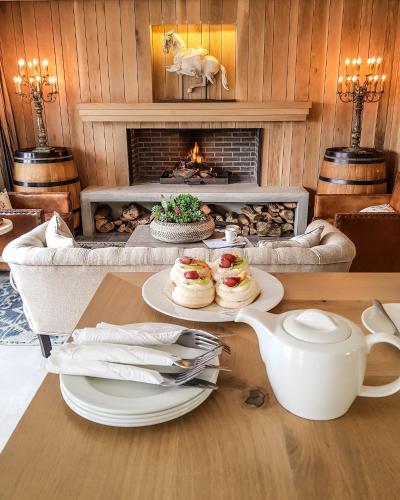 a table with plates of food in front of a fireplace at Bosch Hoek Golf & Lodge in Balgowan
