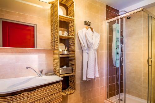 a bathroom with a sink and a shower at Logis Hôtel Restaurant Résidence in Nissan-lez-Enserune