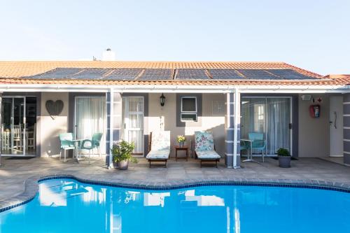 a house with a swimming pool and a patio at Atlantic Beach Villa in Cape Town