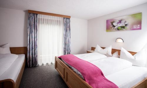 ein Hotelzimmer mit 2 Betten und einem Fenster in der Unterkunft Apart Peter in Kappl