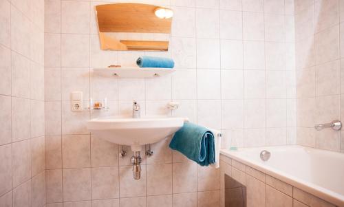 ein weißes Badezimmer mit einem Waschbecken und einer Badewanne in der Unterkunft Apart Peter in Kappl