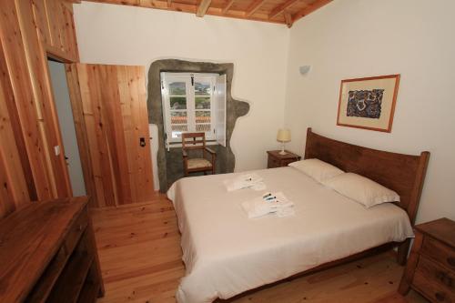 ein Schlafzimmer mit einem Bett in einem Zimmer mit einem Fenster in der Unterkunft Casa Branca do Imperio in Cinco Ribeiras