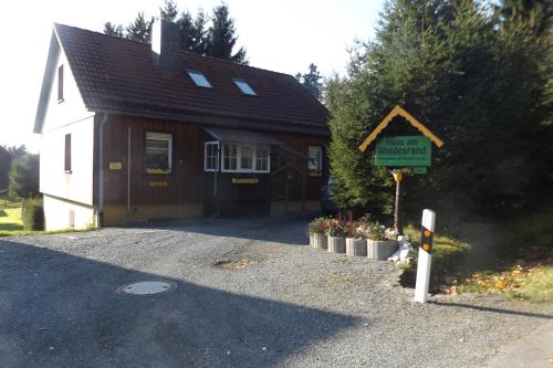 ein kleines Haus mit einem Schild davor in der Unterkunft Haus am Waldesrand in Tanne