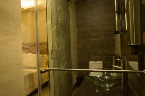 a bathroom with a glass shower door with a sink at 212 Hotel in Santa Rosa de Cabal