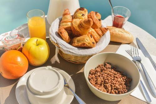 a table with a basket of pastries and a bowl of nuts at Logis Hôtel Restaurant Résidence in Nissan-lez-Enserune