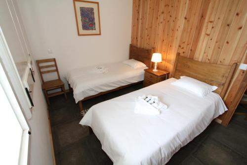 two beds in a hotel room with white sheets at Casa Branca da Sociedade in Angra do Heroísmo