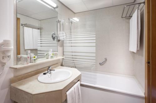 a white bathroom with a sink and a shower at TRH Taoro Garden - Only Adults in Puerto de la Cruz