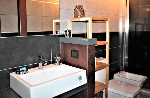 a bathroom with a white sink and a toilet at Appartamento Via Mazzini in Rovigo
