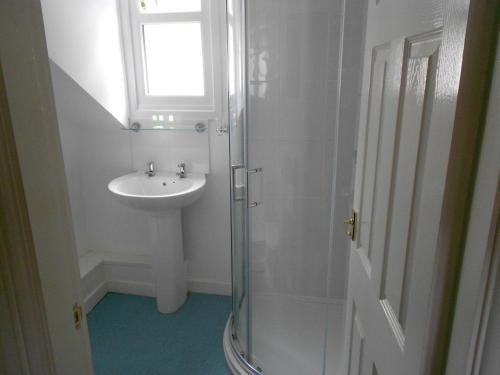 a bathroom with a sink and a glass shower at The Glan Yr Afon Inn in Holywell