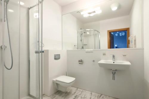 a bathroom with a toilet and a sink and a shower at Hotel Dom Marynarza in Gdynia