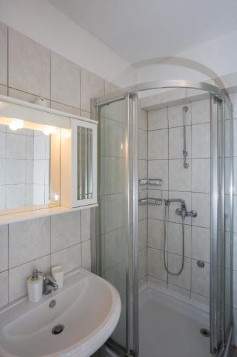 a white bathroom with a shower and a sink at Apartment Pradini in Poljana