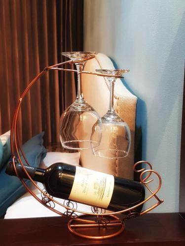 a wire wine rack with a bottle and glasses at Yellow Tree Suites in Fortuna