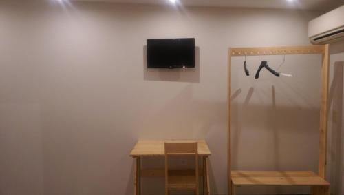 卡巴內斯的住宿－埃爾拉克德納瓦雷特賓館，一间配有电视的墙上客房,配有一张桌子