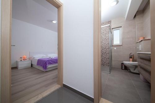 Un dormitorio con una cama y un baño con espejo. en Villa Ivka, en Makarska
