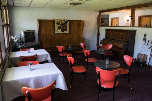 een eetkamer met tafels en stoelen en een tv bij The Wayside Inn in Bethlehem