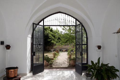 an archway with an open door to a garden at Residenza Storica PARCO LANOCE in Poggiardo