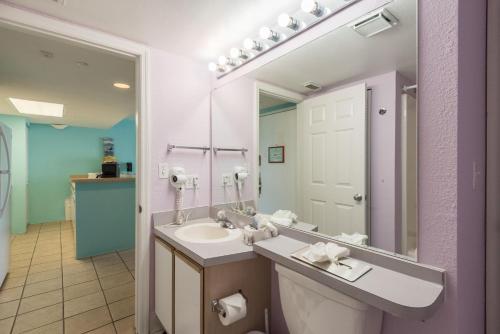 bagno con lavandino e grande specchio di Sunrise Suites Cozumel Suite #112 a Key West