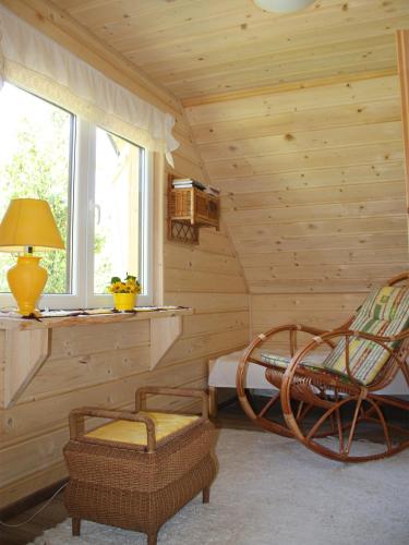 a log room with a chair and a table and a lamp at Młynarzowa Chata in Lesko
