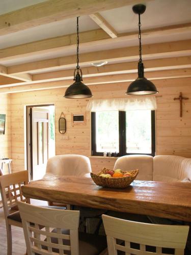 a dining room with a wooden table with a bowl of fruit at Młynarzowa Chata in Lesko