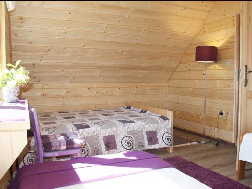 a bedroom with a bed in a wooden room at Młynarzowa Chata in Lesko