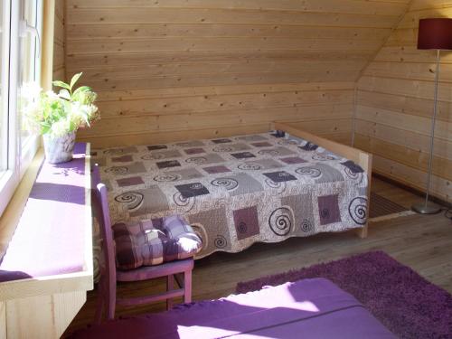 a bedroom with a bed in a wooden room at Młynarzowa Chata in Lesko